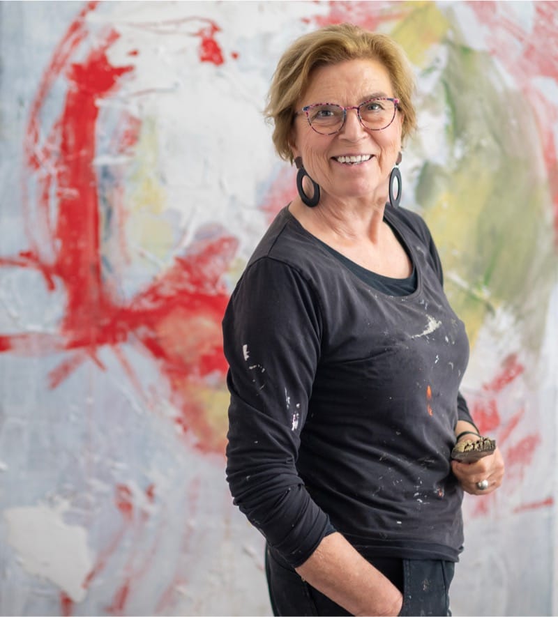 Marian Siereveld in een blauwe jurk voor haar schilderij